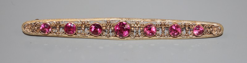 An early 20th century yellow metal and graduated pink tourmaline set bar brooch, 82mm, gross 6.4 grams.